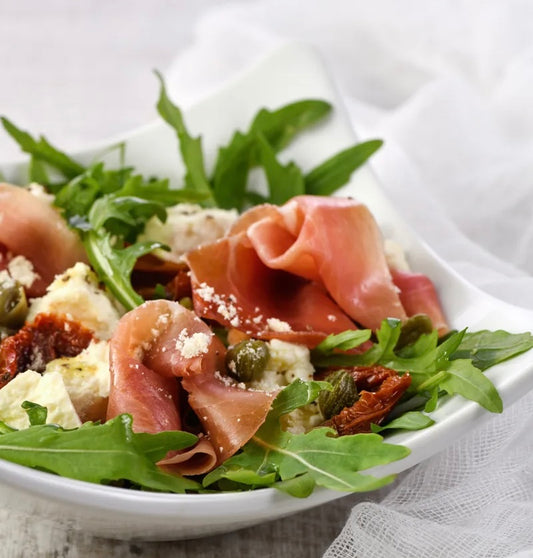 Salade de farfalles au pesto, roquette, proscuitto, bocconcinni & tomates rôties